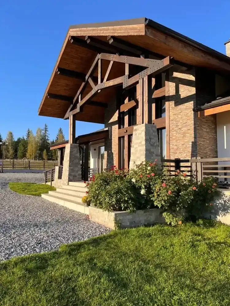 Intrarea în Chalet Deluț, cu terasă și flori