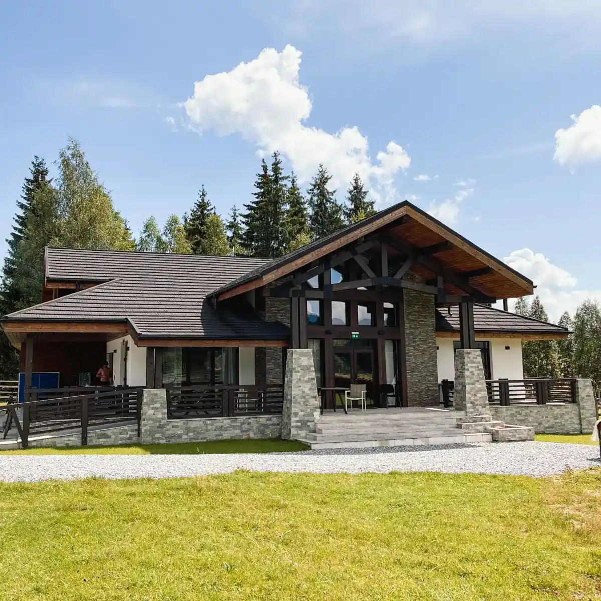 Chalet Deluț văzut din curte, între brazi